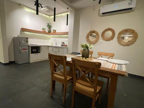 cocina con mesa de madera y sillas en fun beach durrat alarous -فن بيتش درة العروس, en Durat Alarous