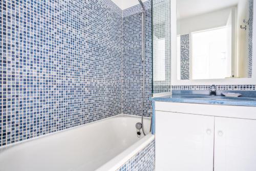 une salle de bain avec une baignoire, un lavabo et un miroir dans l'établissement Résidence le Hameau de Cap Esterel - maeva Home - Appartement 2 Pièces 5 Personnes - Sélection MAE-8433, à Saint-Raphaël