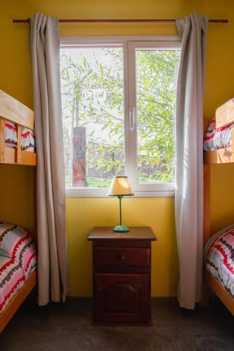 a bedroom with a window and a table with a lamp at Cabañas Costa del Percy in Trevelin