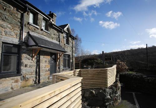 a house with a wooden fence next to a building at Bryn Glo in Capel-Curig