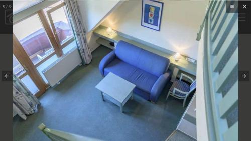 a living room with a blue couch and a table at Tavasz in Cserszegtomaj