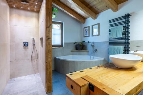 uma casa de banho com uma banheira grande e um lavatório em Hochwart Apartment - mit eigenem Garten em Saalbach Hinterglemm