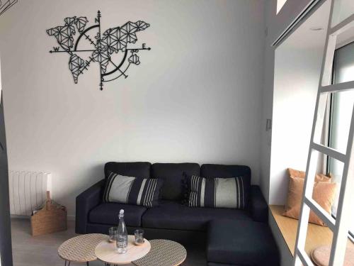 un salon avec un canapé noir et une table dans l'établissement Studio charmant au cœur de Clermont-Ferrand, 30 m², cheminée, à Clermont-Ferrand