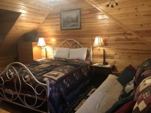 a bedroom with a bed in a log cabin at Duck`s Nest Retreat in Turtletown