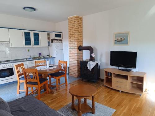 a living room with a table and a kitchen at Medjugorje Perfect family house in Međugorje
