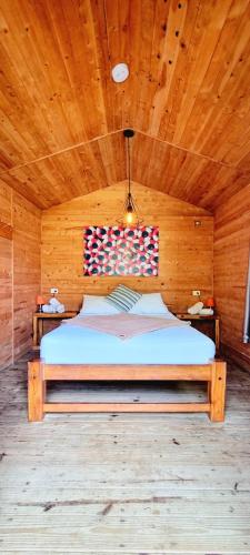 a bedroom with a bed in a wooden room at Blue Mango Beach Hotel in Guachaca
