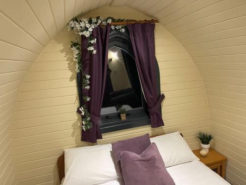 a bedroom with a mirror and a bed with purple curtains at Belle Vista Glamping & Camping in York