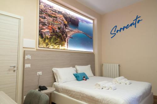 a bedroom with a bed with a picture on the wall at THE SUN HOTEL BOUTIQUE NAPOLI in Naples