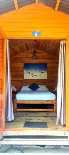 a bedroom with a bed in a wooden house at Blue Mango Beach Hotel in Guachaca