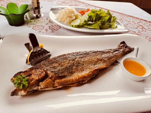 a plate of fish with a salad and dipping sauce at Hotel | Restaurant | Forellenzucht in Burgen