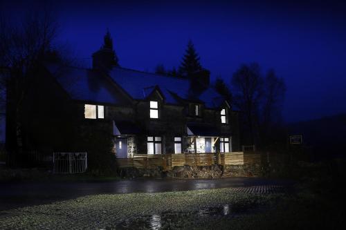 a large house at night with its lights on at Bryn Glo in Capel-Curig