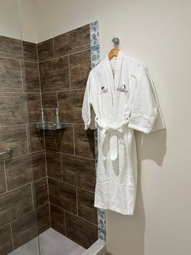 a robe on a hanger in a bathroom at Los Robles Apart Hotel l Suites & Spa in Sierra de la Ventana