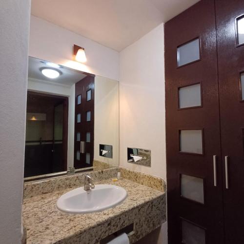 a bathroom with a sink and a mirror at Sleep Inn Puebla Centro Hist rico in Puebla