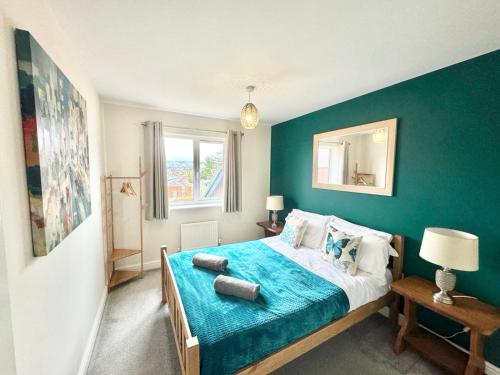 a bedroom with a bed with a blue wall at 3 Bedroom Home centrally located in Folkestone, great location for contractors or families with parking in Folkestone