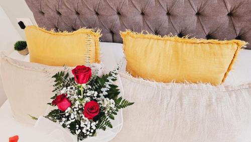 three pillows with red roses on a bed at Loft con Jacuzzi os Arcos in Sober