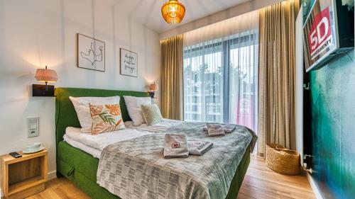 a bedroom with a bed with two towels on it at Apartament Schellter 62 przy Wydmach - by 5D Apartamenty in Rogowo