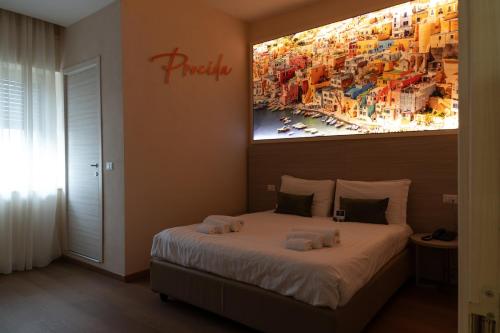 THE SUN HOTEL BOUTIQUE NAPOLI في نابولي: غرفة نوم بسرير مع لوحة على الحائط