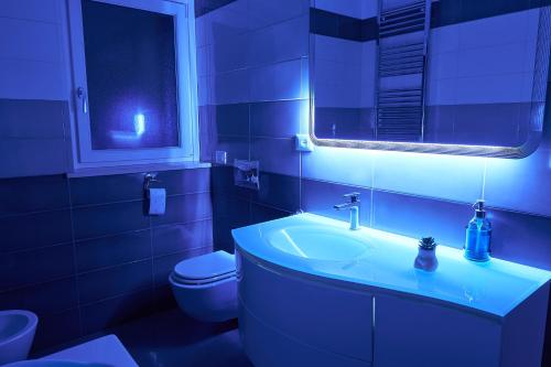 a bathroom with a sink and a toilet with a blue light at GRANDE TERRAZZA CON VISTA MARE parziale in Francavilla al Mare