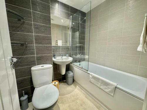 a bathroom with a toilet and a sink and a tub at 3 Bedroom Home centrally located in Folkestone, great location for contractors or families with parking in Folkestone