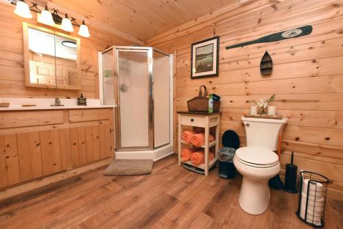 a bathroom with a shower and a toilet in a log cabin at Poplar Ridge Retreat in Blairsville