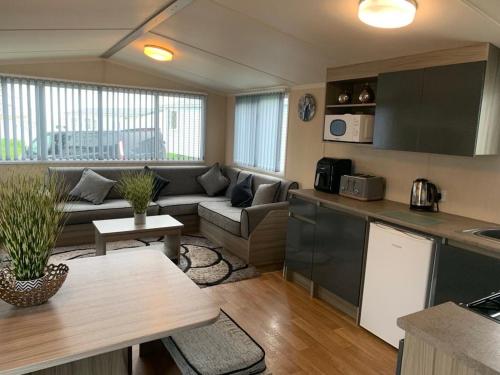 a kitchen and living room with a couch and a table at Littlesea haven Rachel’s retreat in Wyke Regis