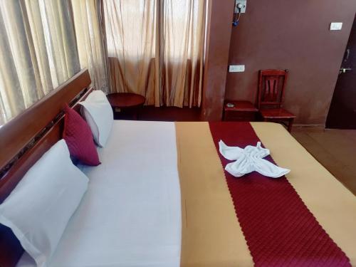 a hotel room with a bed with a red and white blanket at Hotel Sea Sunrise in Calangute