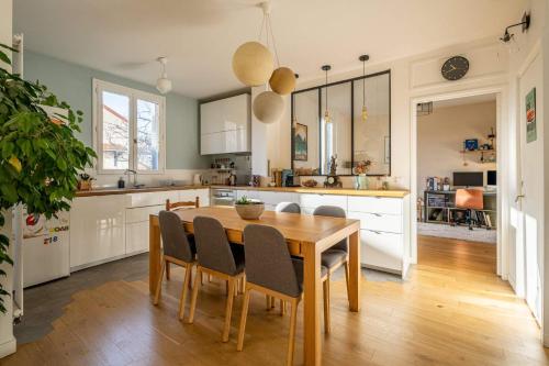 uma cozinha com uma mesa de madeira e cadeiras em Chambre avec Salle de Bain privative #Paris2024 em Courbevoie