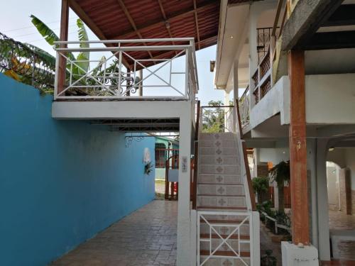 a staircase leading up to a blue building with a balcony at Apartamento de tranquilidad. in La Ceiba