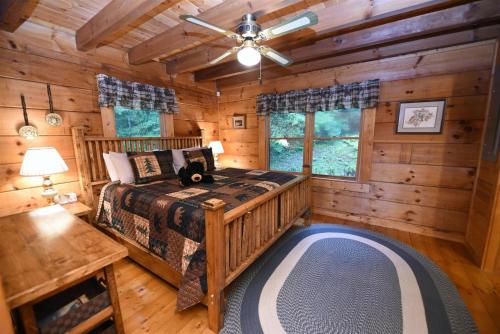 a bedroom with a bed in a log cabin at Simpler Times- Mineral Bluff in Mineral Bluff