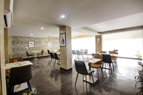 um restaurante com mesas e cadeiras num quarto em FlxHo Quad - Luxury Studio Apart Hotel DLF Cyber City em Gurgaon