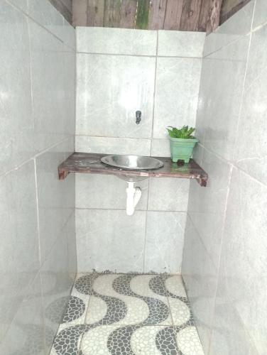a bathroom with a sink on a tiled wall at cabana sabiá in Camaçari