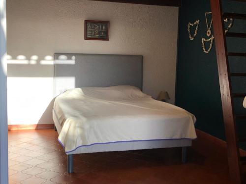 1 dormitorio con 1 cama con colcha blanca en Villa A Pineta, en Porticcio