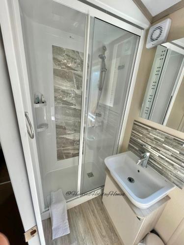 uma casa de banho com um chuveiro e um lavatório. em Windermere View Lodge - White Cross Bay em Windermere