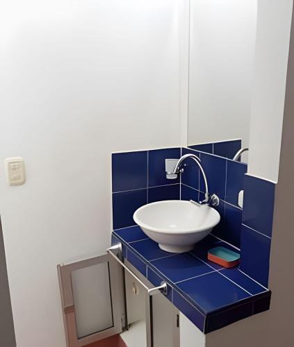 a blue tiled bathroom with a sink and a mirror at Casa mediterránea con piscina, aire, WI-FI y cocina in Carmen de Apicalá