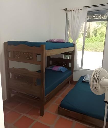 a room with two bunk beds and a window at Casa mediterránea con piscina, aire, WI-FI y cocina in Carmen de Apicalá