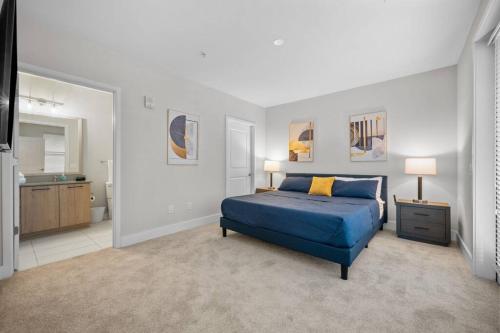 a bedroom with a blue bed and a bathroom at Lux 3BR Near Truist Park & Mall in Atlanta