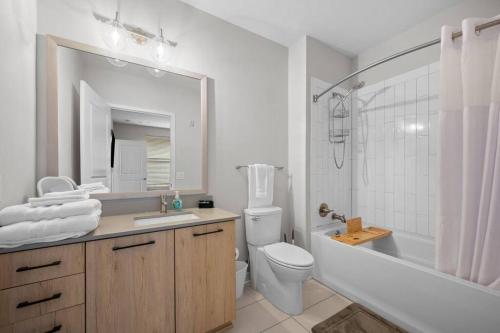 a bathroom with a sink and a toilet and a mirror at Lux 3BR Near Truist Park & Mall in Atlanta