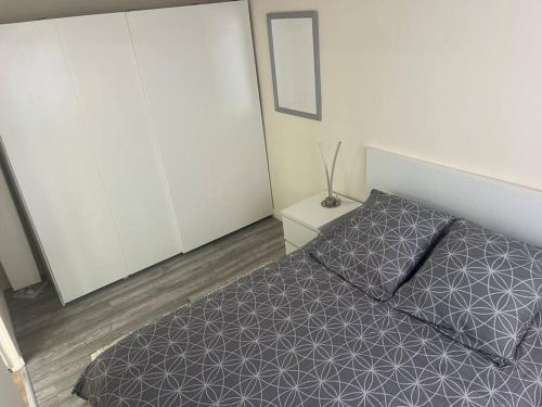 - une chambre avec un lit et une couette grise dans l'établissement Maison indépendante, à Gaillon