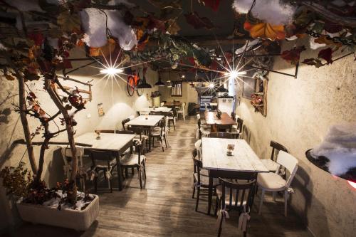 un restaurante con mesas, sillas y un árbol en Locanda Al Cacciatore, en Seren del Grappa