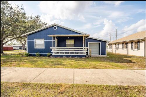 a blue house with a garage in a yard at 3-Bed Bungalow walk to Historic Downtown Sanford in Sanford