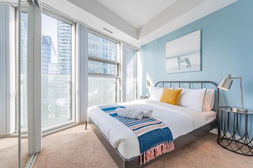 1 dormitorio con 1 cama y ventanas grandes en Downtown Apartments 3, en Toronto