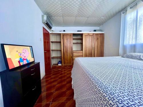 a bedroom with a bed and a flat screen tv at Departamento Suite frente al Mar in Manta