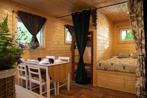Zimmer mit einem Tisch und einem Bett in einer Hütte in der Unterkunft Stanica Wodna Swoboda in Augustów