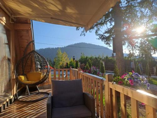 a porch with a chair and a swing at ZLATARSKA IDILA in Nova Varoš