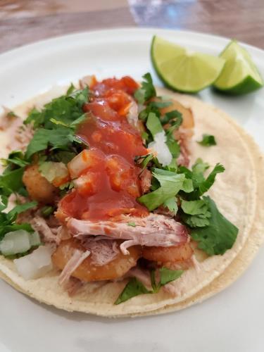 a taco with meat and vegetables on a white plate at Hostal Casa Del Sol Comitan in Comitán de Domínguez