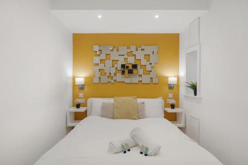 a bedroom with a white bed with two slippers at Central and Modern one bedroom flat in Oxford