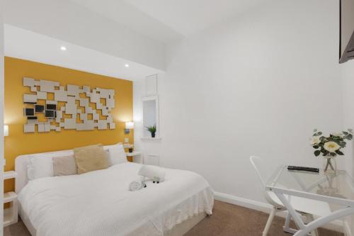 a bedroom with a white bed and a glass table at Central and Modern one bedroom flat in Oxford