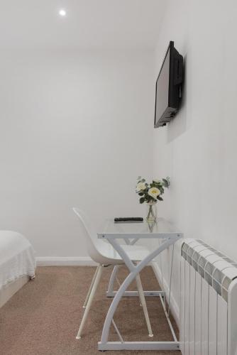 a white desk with a television on a wall at Central and Modern one bedroom flat in Oxford