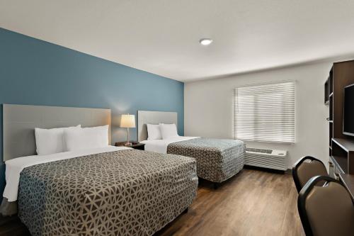 a hotel room with two beds and a window at WoodSpring Suites Fort Collins in Fort Collins