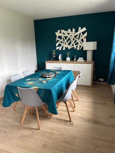 une salle à manger avec une table et des chaises bleues dans l'établissement Maison au calme avec spa et rivière à côté de CHARTRES, à Saint-Prest